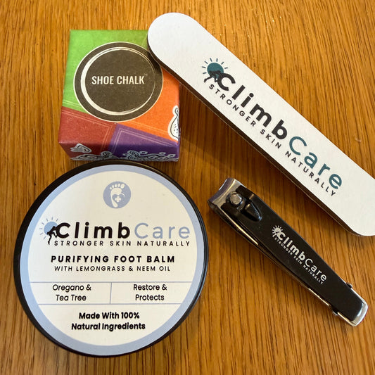 ClimbCare skincare products including balm, nail file, and shoe chalk on a wooden surface.