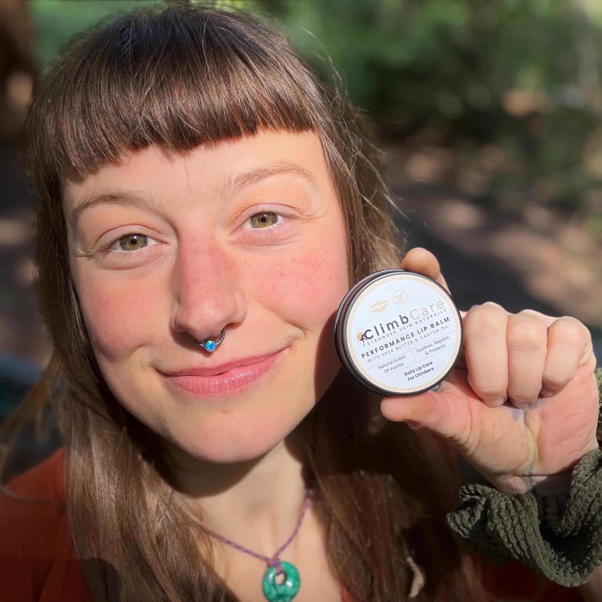 Woman holding a tin of climbcare vegan lip balm
